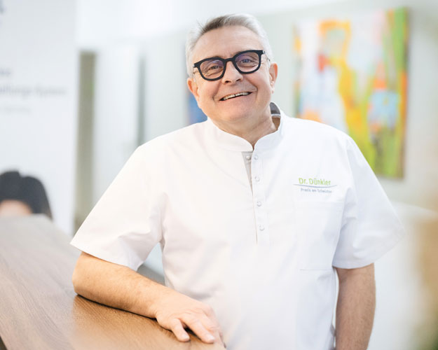 Frontaufnahme von Frau Simone Dünkler, die lächelnd mit verschränkten Armen in die Kamera schaut